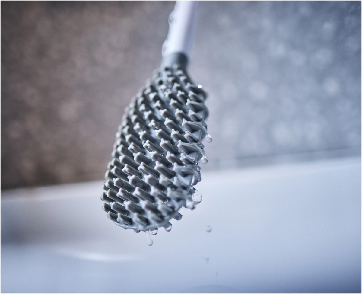 Weisse WC-Bürste Flex TriBlade von Joseph Joseph mit passendem geschlossenem Halter, schlanke Form, glänzende Oberfläche, freistehend im Badezimmer.