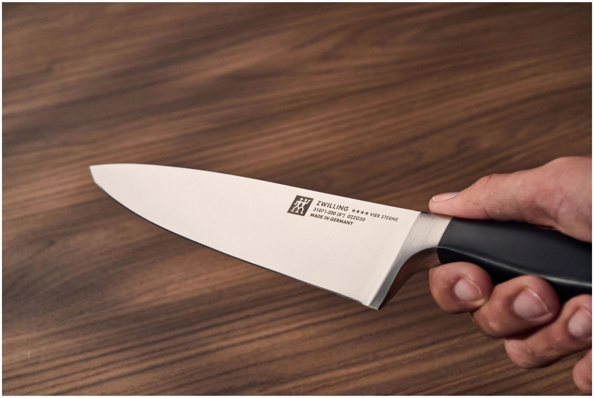 Schwarzes Kochmesser mit 18 cm langer, geschwungener Klinge aus Stahl und ergonomischem Kunststoffgriff von Zwilling, fugenloser Übergang zur Klinge.