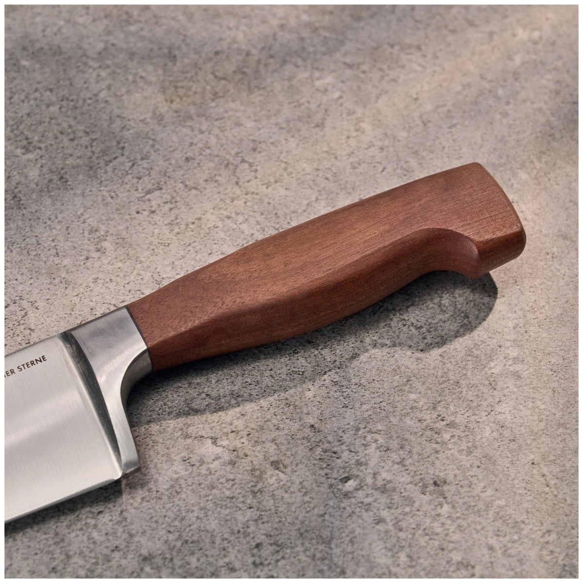 Kochmesser Zwilling Vier Sterne Wood mit brauner Klinge, geschwungener Form und Griff aus Kotibé-Holz, 20cm Klingenlänge, Ansicht von der Seite.
