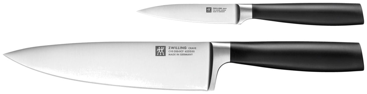 Zwei Küchenmesser von Zwilling aus der Crave-Serie, ein kleines Schälmesser und ein grosses Kochmesser mit ergonomischem Griff, nebeneinander liegend.