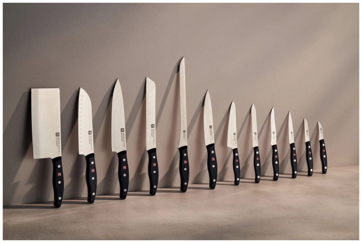 Zwilling Signature Schälmesser mit 6cm langer, gebogener Klinge aus Edelstahl und ergonomischem Griff im Drei-Nieten-Design.