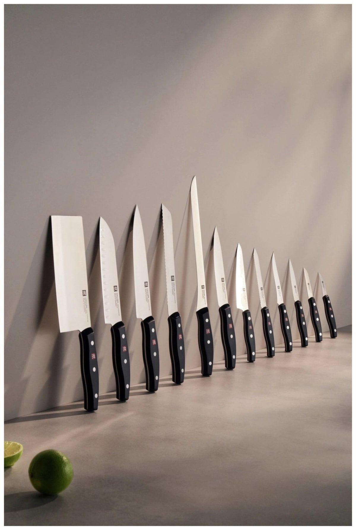 Zwei Küchenmesser von Zwilling: ein Schälmesser und ein Kochmesser mit Edelstahlklinge und Griff im Drei-Nieten-Design, nebeneinander liegend.