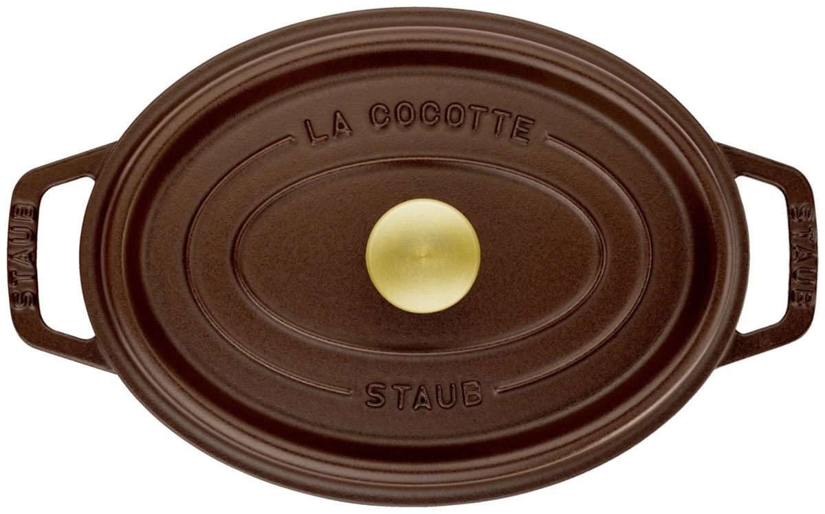 Ovale Staub Cocotte aus Gusseisen in brauner Emaille-Optik, 23 cm lang, mit Deckel und Tropfenstruktur auf der Innenseite.