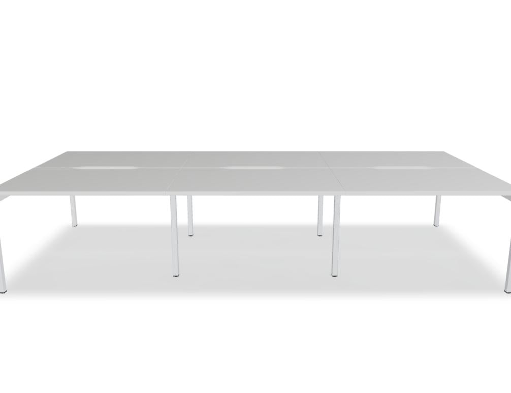 Junger Mann sitzt an einem modernen Doppelschreibtisch Ogi Y Bench BOY32E3 mit Holz- und Metallakzenten, hellen Arbeitsflächen, praktischen Ablagen und ordentlicher Bürolandschaft.