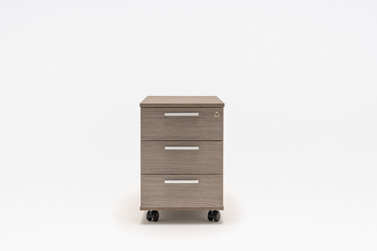 Rollcontainer Quando von Mdd in Kanadischer Eiche mit schwarzen Kunststoffschubladen, Aluminiumgriffen und Rollen mit Bremsen.