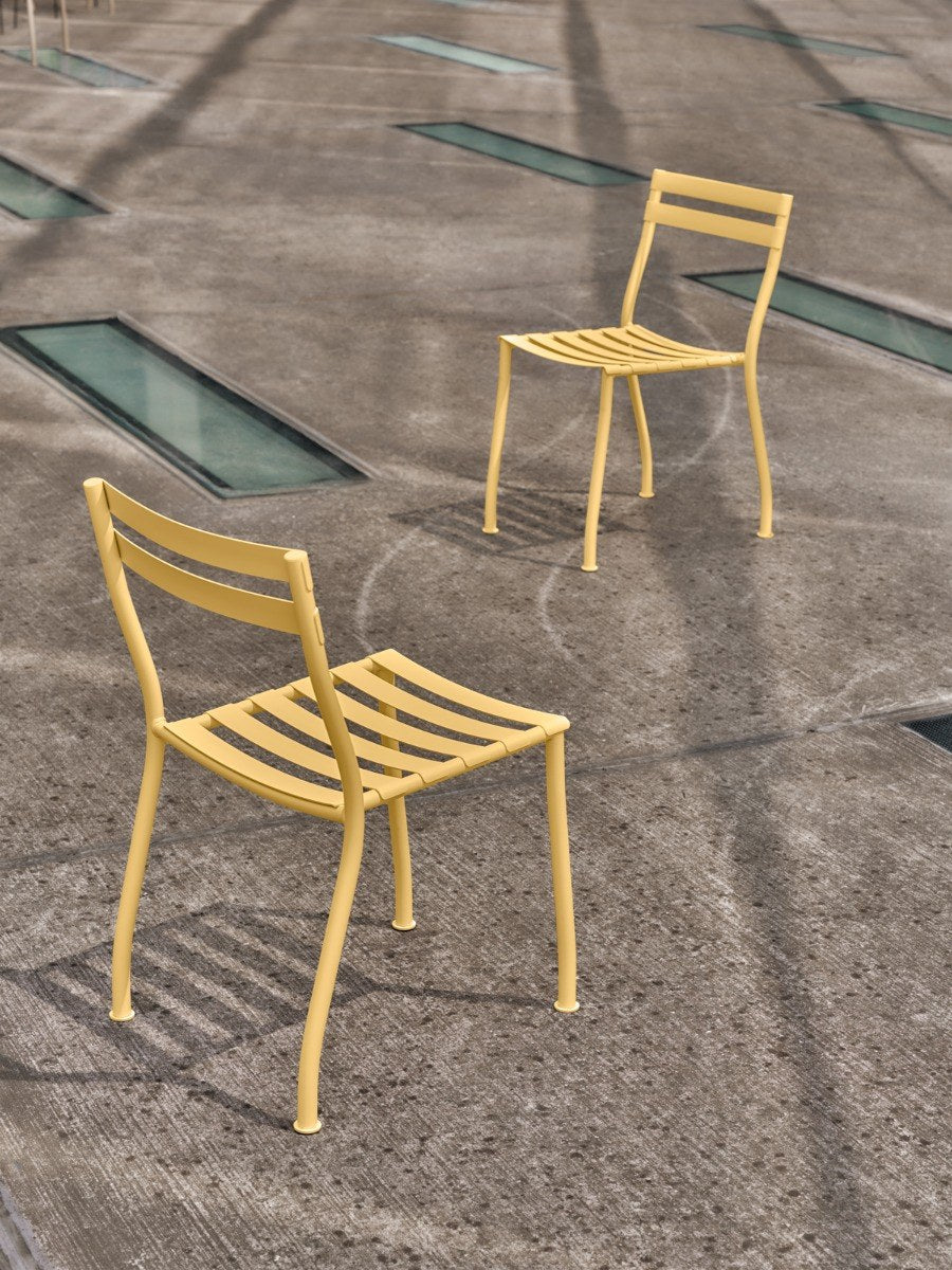 Zwei stapelbare Gartenstühle Flaner von Mdd aus verzinktem, pulverbeschichtetem Stahl in Türkis matt mit schwarzen Kunststofffüssen.