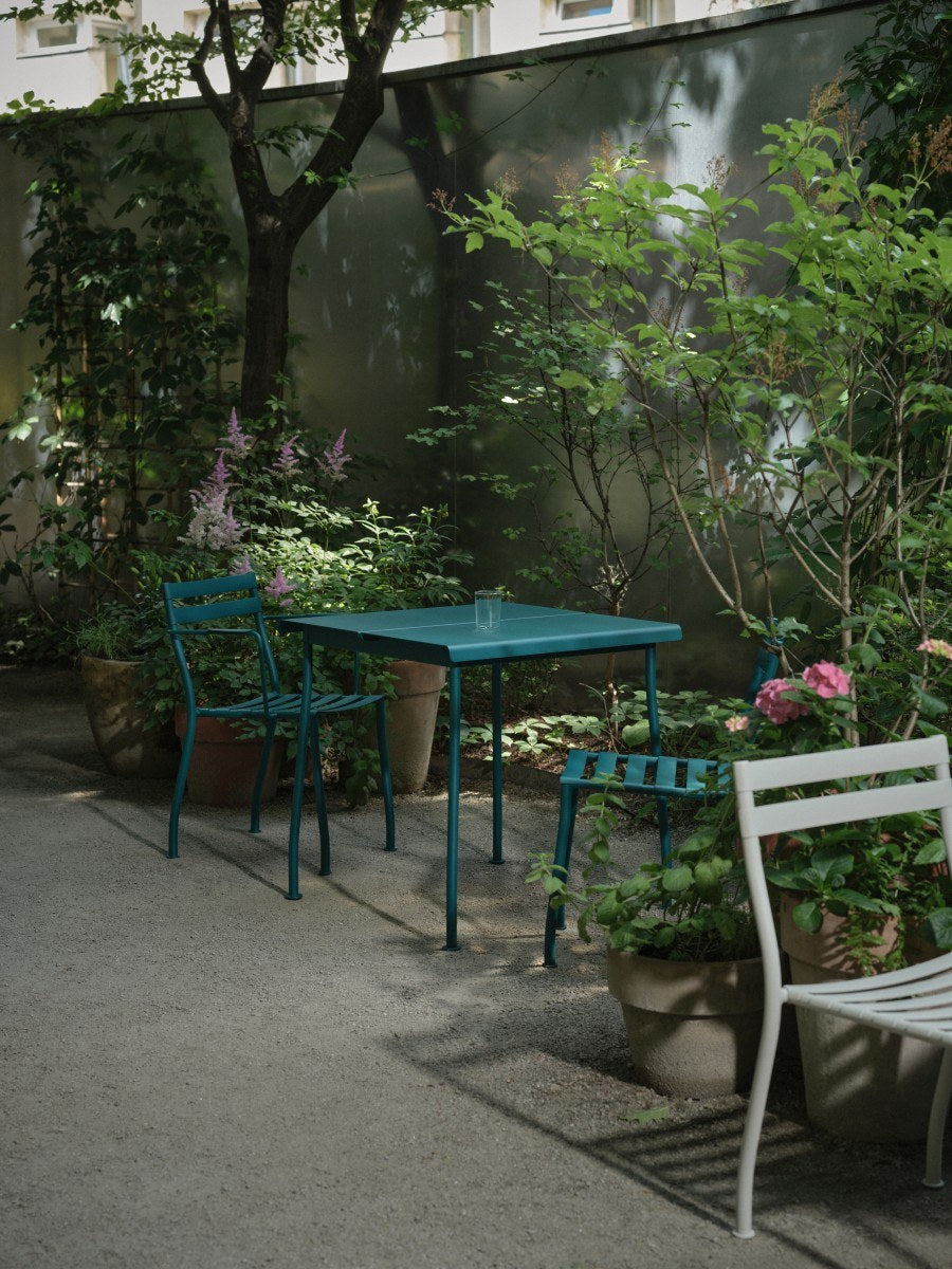 Zwei stapelbare Gartenstühle Flaner von Mdd aus verzinktem, pulverbeschichtetem Stahl in Türkis matt mit schwarzen Kunststofffüssen.