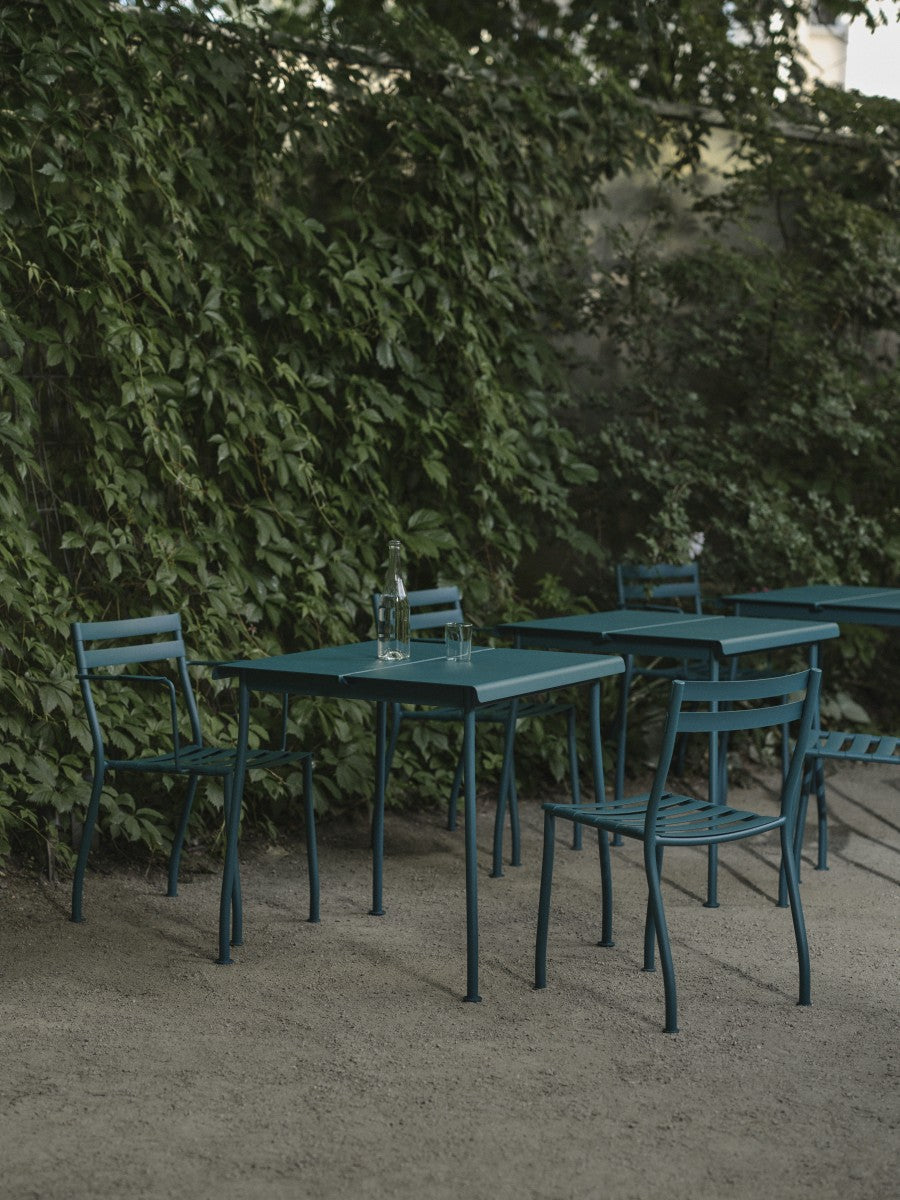 Quadratischer Cafeteriatisch Flaner aus verzinktem, pulverbeschichtetem Stahlblech in matter türkiser Struktur mit runden Stahlrohrbeinen.