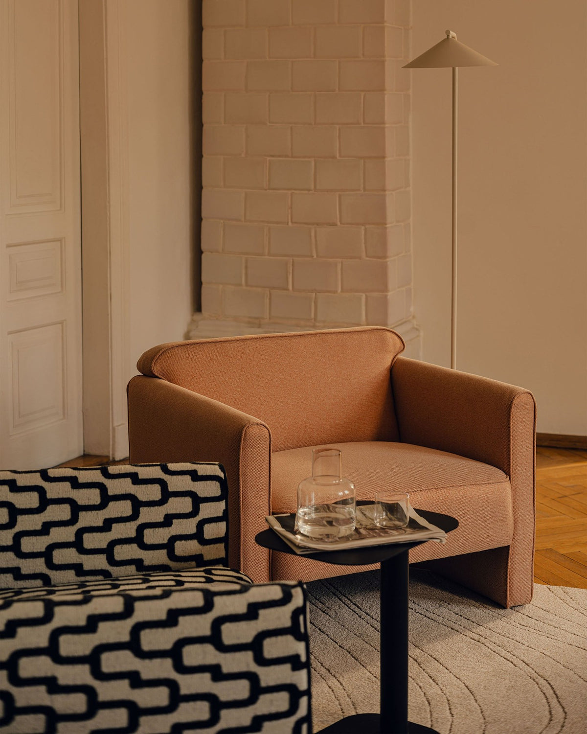 Beiges 2er Sofa Abby von Micadoni mit gepolsterter Sitzfläche, niedrigen schwarzen Kunststoffbeinen und schlichtem, abgerundetem Design.