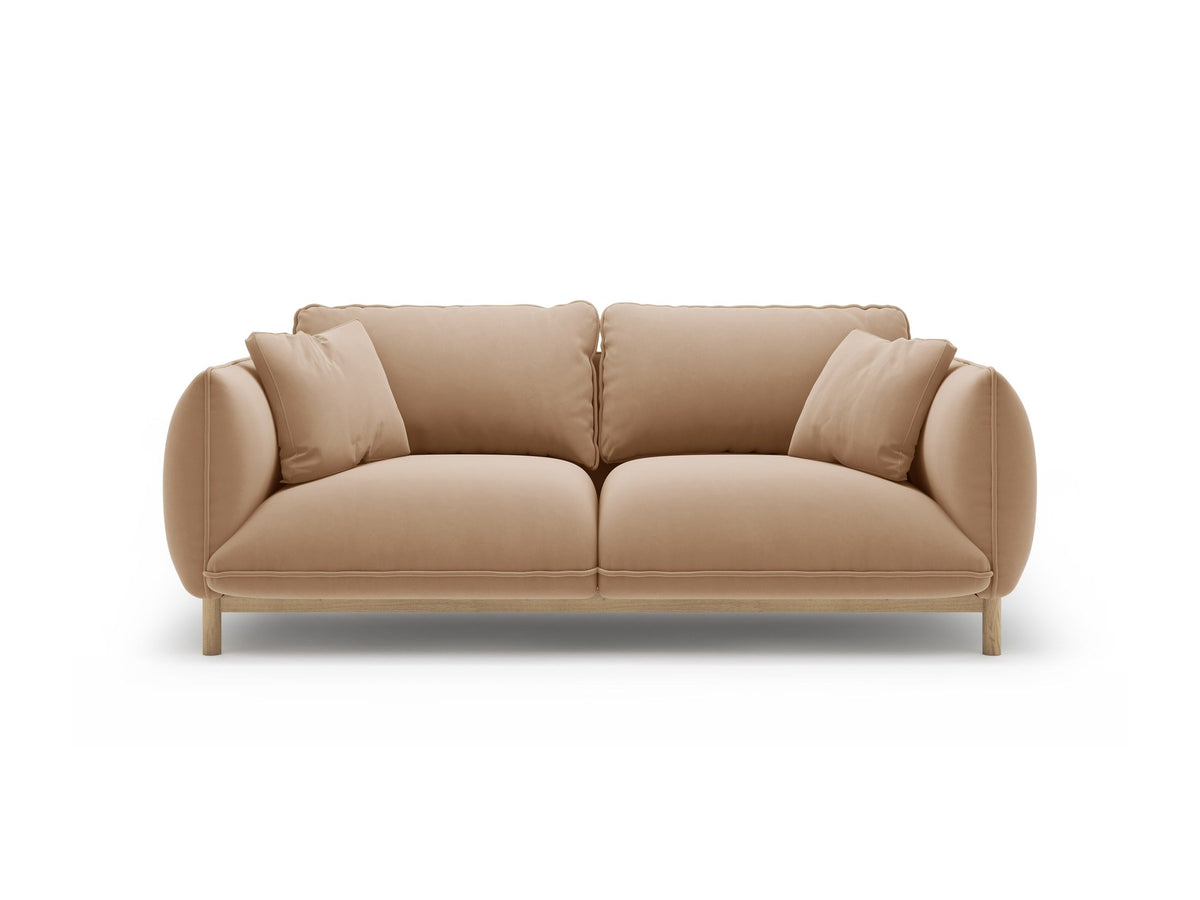 Ada 2er Sofa von Micadoni in Mandel beige mit gepolstertem Velours-Bezug, geschwungener Rückenlehne und sichtbaren Buchenholzbeinen.