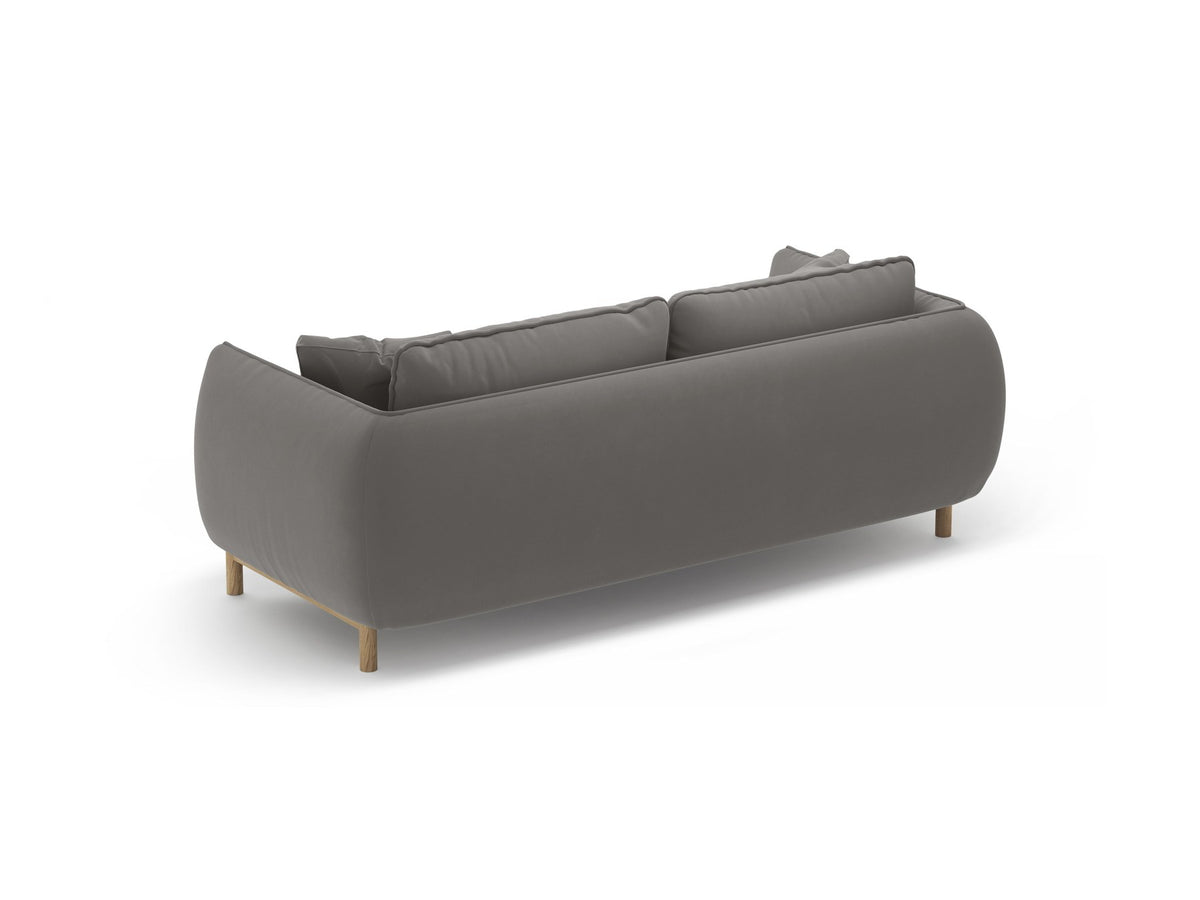 Ada 2er Sofa von Micadoni in Mandel beige mit gepolstertem Velours-Bezug, geschwungener Rückenlehne und sichtbaren Buchenholzbeinen.