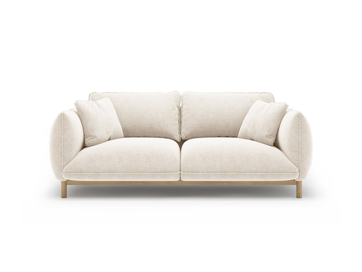 Ada 2er Sofa von Micadoni in Mandel beige mit gepolstertem Velours-Bezug, geschwungener Rückenlehne und sichtbaren Buchenholzbeinen.