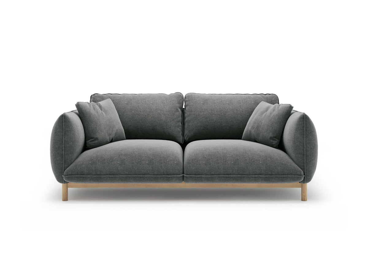 Ada 2er Sofa von Micadoni in Mandel beige mit gepolstertem Velours-Bezug, geschwungener Rückenlehne und sichtbaren Buchenholzbeinen.