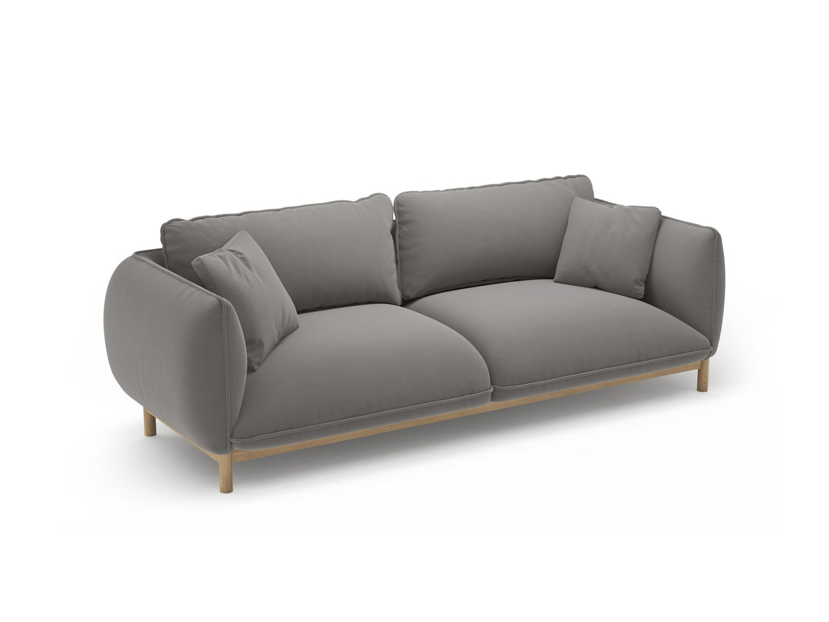 Dreisitzer-Sofa Ada von Micadoni mit geschwungener Form, Casino-Velours-Bezug in Mandel Beige und Buchenholzbeinen.