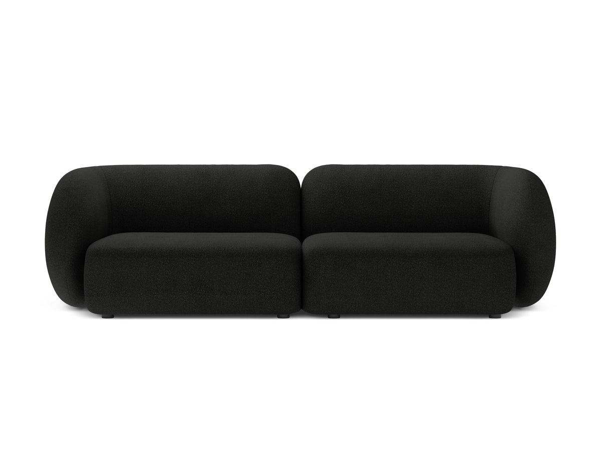 Weisses 4er Sofa Kate von Micadoni mit strukturiertem Bouclé-Stoff, schwarzen Kunststoffbeinen und breiter Sitzfläche.