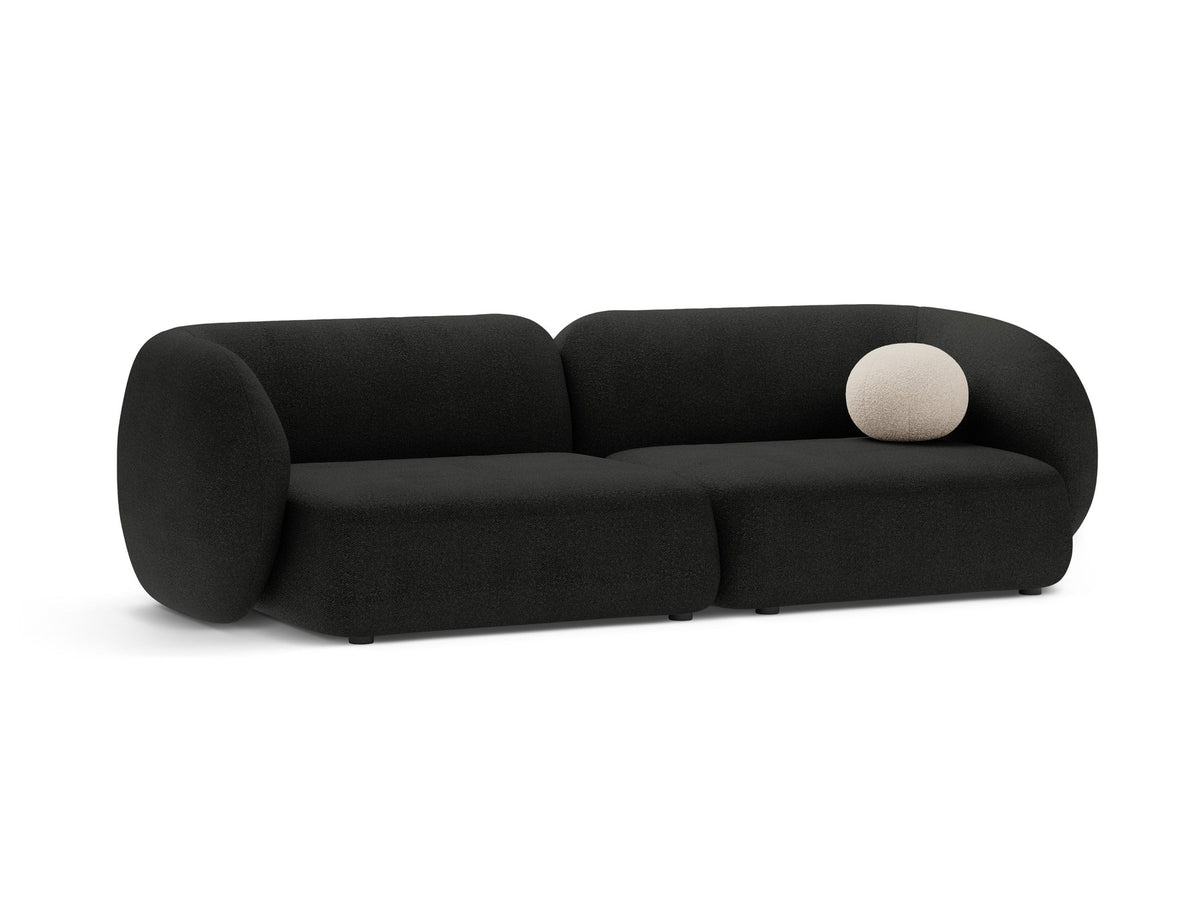 Weisses 4er Sofa Kate von Micadoni mit strukturiertem Bouclé-Stoff, schwarzen Kunststoffbeinen und breiter Sitzfläche.