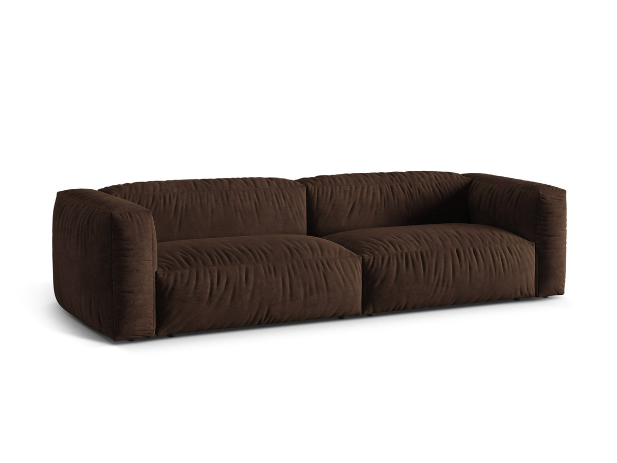 Modulares 4er Sofa Martina XL von Micadoni in Schokolade, Veloursstoff Vogue, schwarze Kunststoffbeine, im Wohnzimmer platziert.