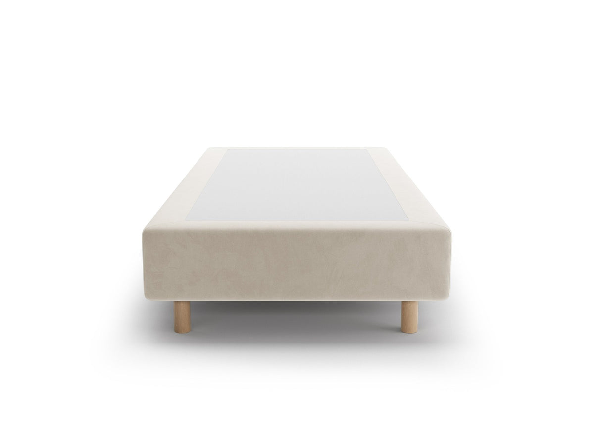 Bettgestell Whale von Micadoni in leichtem Beige mit Chenille-Bezug und Buchenholzbeinen, minimalistische Form ohne Kopfteil, Ansicht von schräg vorne.