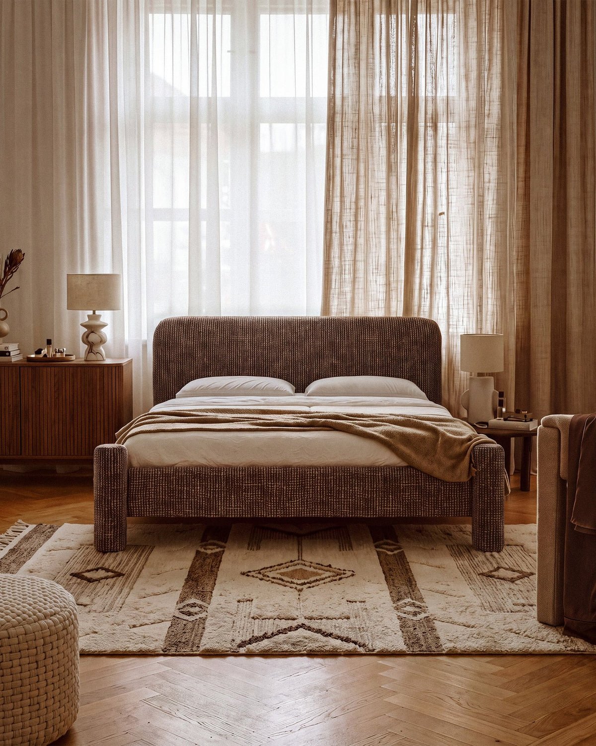 Foto des Vera Betts mit gepolstertem, abgerundetem Kopfteil in leichtem Beige, Chenille-Stoff und gepolsterten Holzbeinen.