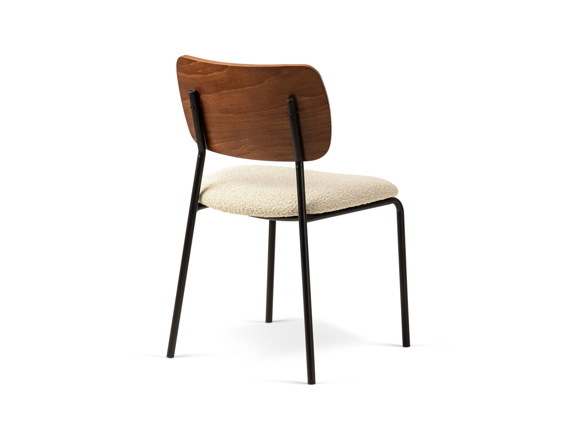 Beiger Samtstuhl mit gepolstertem Sitz aus Bouclé-Stoff, ergonomischer Rückenlehne aus Buchenholz und schwarzen Stahlbeinen im Esszimmer.