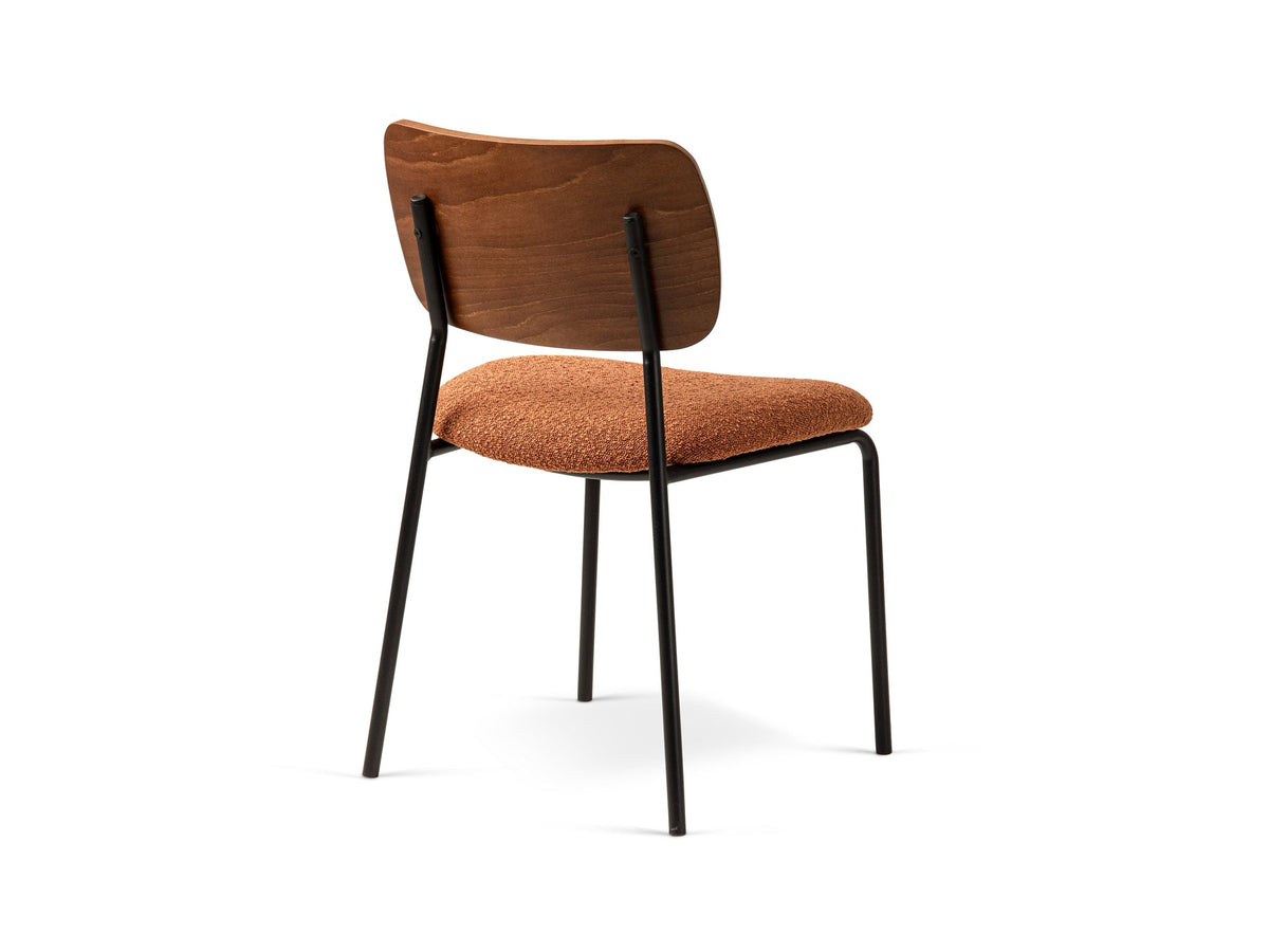 Beiger Samtstuhl mit gepolstertem Sitz aus Bouclé-Stoff, ergonomischer Rückenlehne aus Buchenholz und schwarzen Stahlbeinen im Esszimmer.