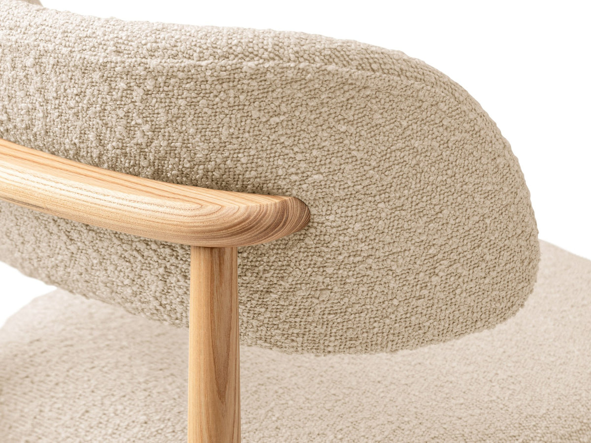 Stuhl Evan von Micadoni in Beige mit strukturiertem Bouclé-Bezug, Sitz- und Rückenpolster sowie Beinen aus natürlichem Buchenholz.