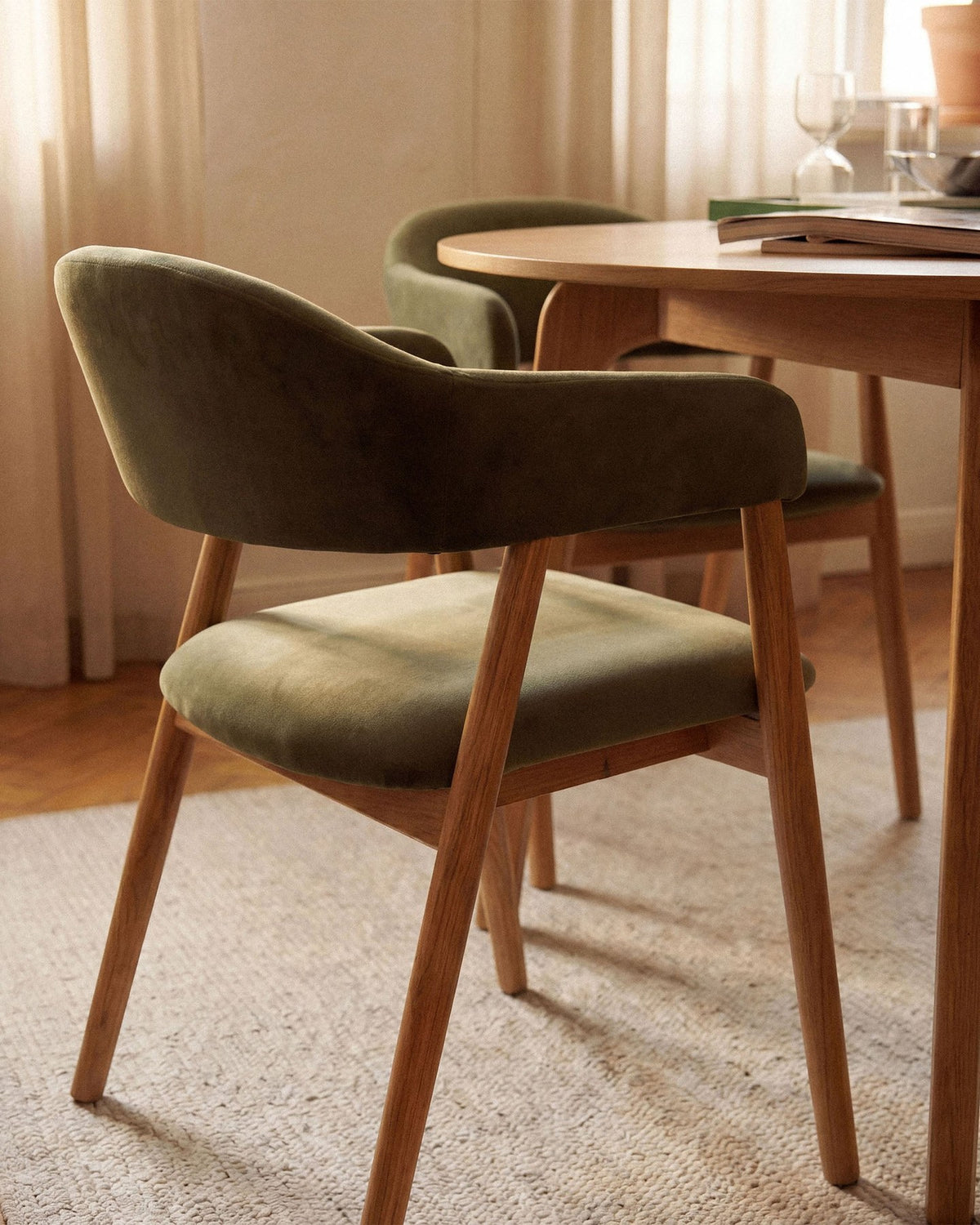 Produktfoto des Adra Samtstuhls von Micadoni: grüner Samtbezug, schwarze Buchenholzbeine, gepolsterte Sitzfläche und Rückenlehne.