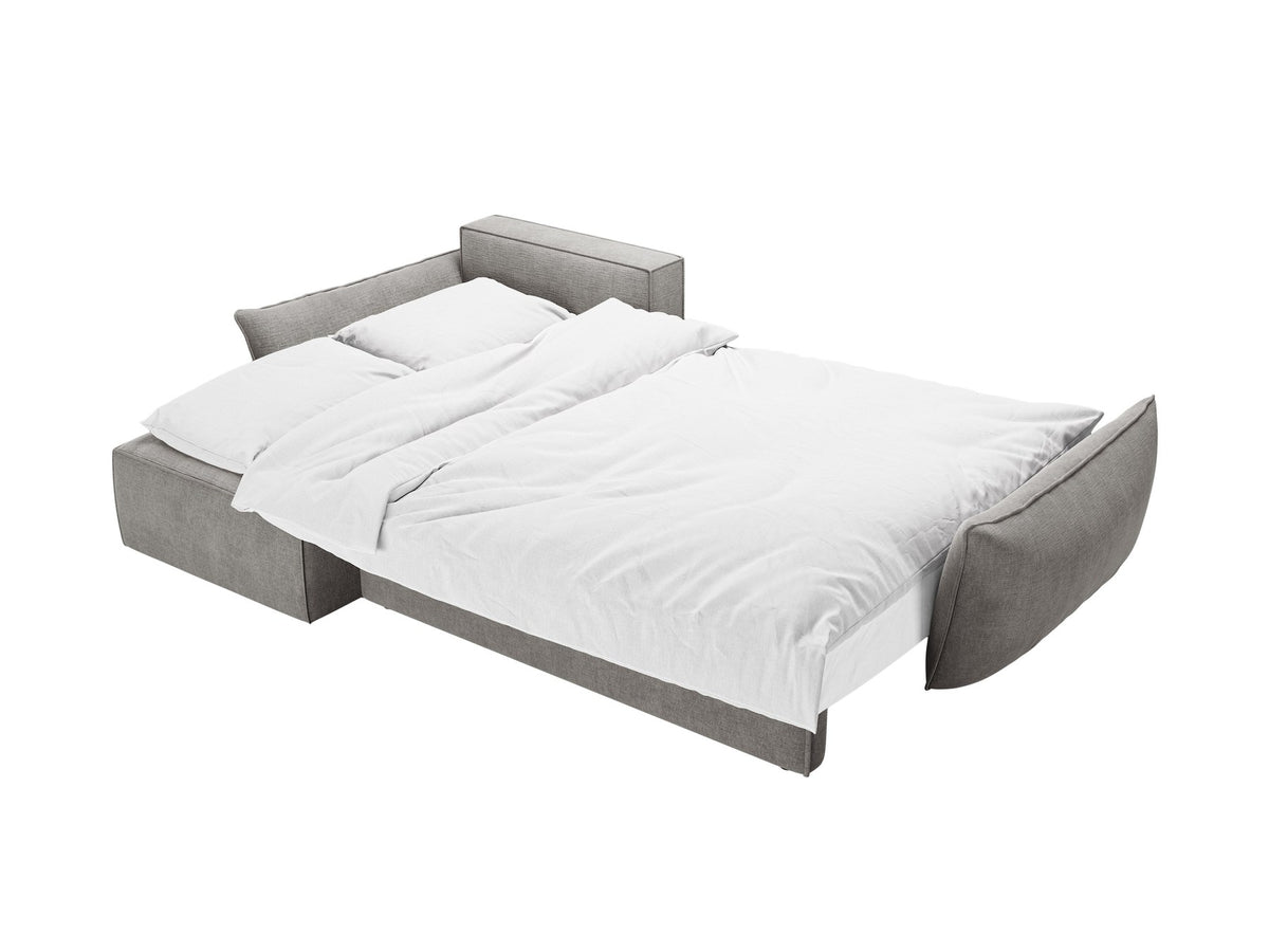 Linksseitiges Ecksofa Kaelle von Micadoni in leichtem Beige mit Chenille-Stoffbezug, schwarzen Kunststoffbeinen und ausklappbarem Bettkasten.