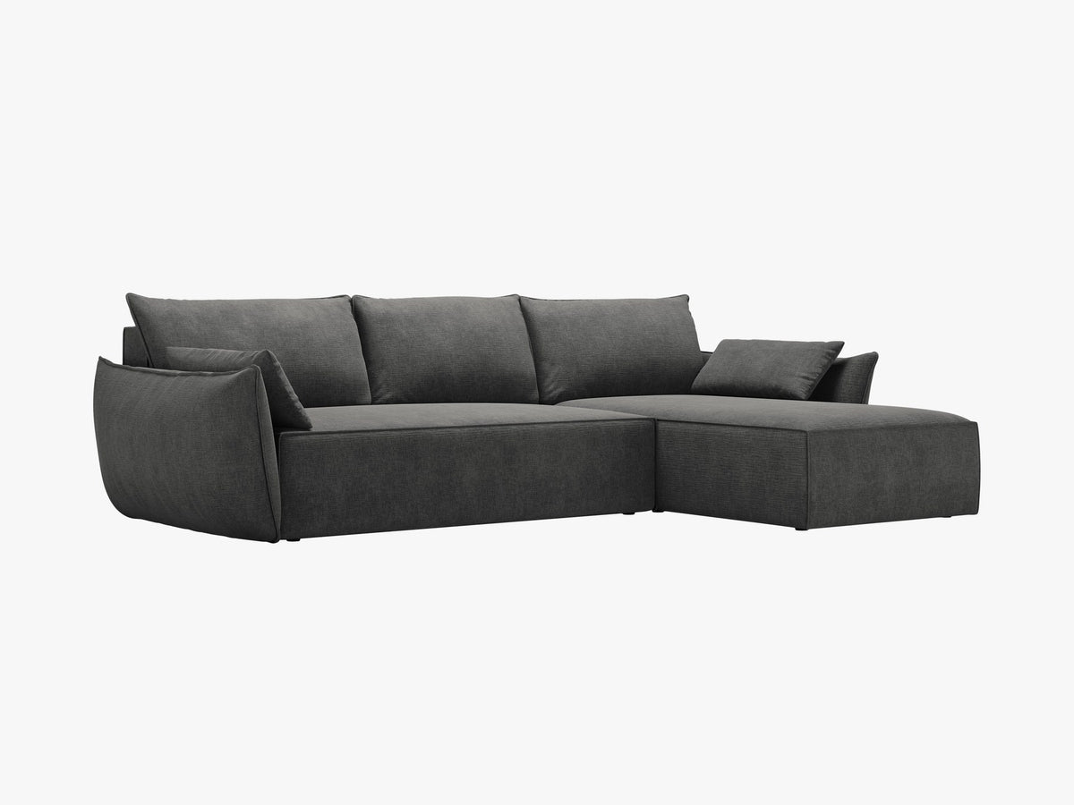 Linksseitiges Ecksofa Kaelle von Micadoni in leichtem Beige mit Chenille-Stoffbezug, schwarzen Kunststoffbeinen und ausklappbarem Bettkasten.