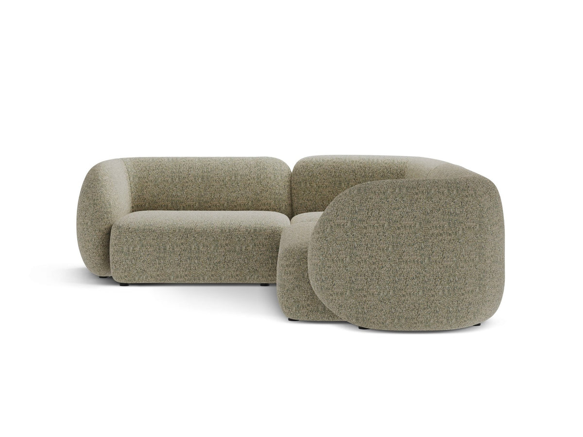 Weisses Ecksofa links Kate von Micadoni mit Bouclé-Stoff Baloo, schwarzen Kunststoffbeinen und niedriger Rückenlehne im Wohnraum.