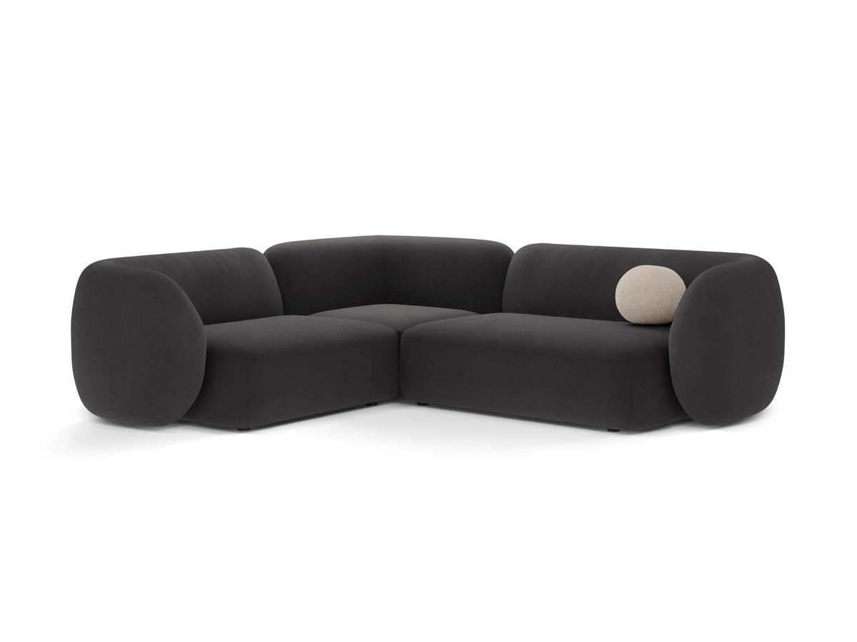 Weisses Ecksofa links Kate von Micadoni mit Bouclé-Stoff Baloo, schwarzen Kunststoffbeinen und niedriger Rückenlehne im Wohnraum.