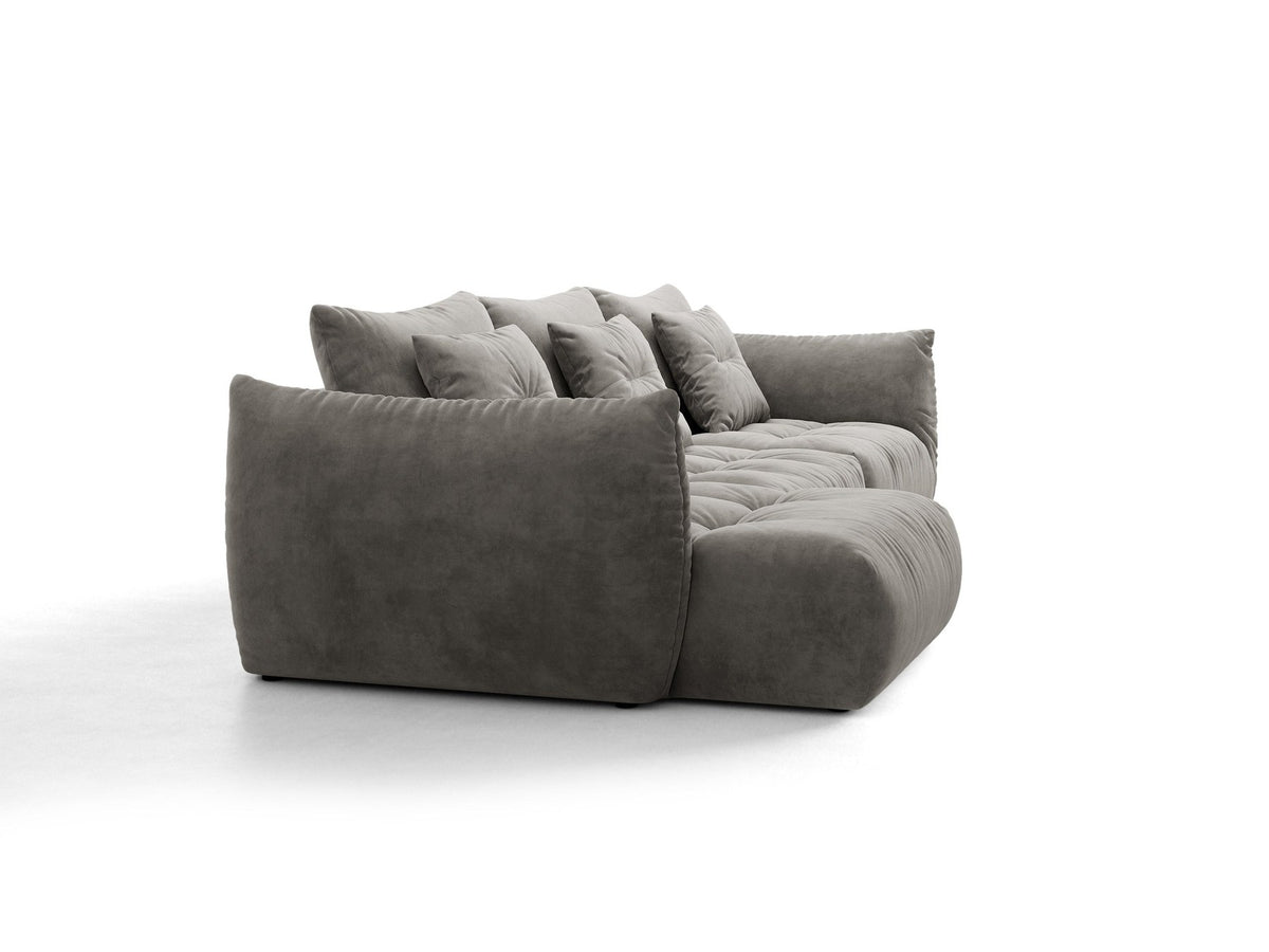 Beiges L-Sofa links von Micadoni mit weichem Veloursstoff Casino, schwarzen Kunststoffbeinen und breiter, tiefer Sitzfläche.