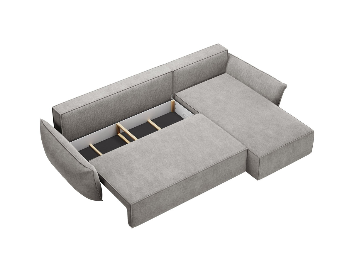 Beige Ecksofa Kaelle von Micadoni mit Chenille-Bezug, schwarzen Kunststoffbeinen und sichtbarem Bettkasten, rechts ausgerichtetes Bettsofa im Wohnraum.