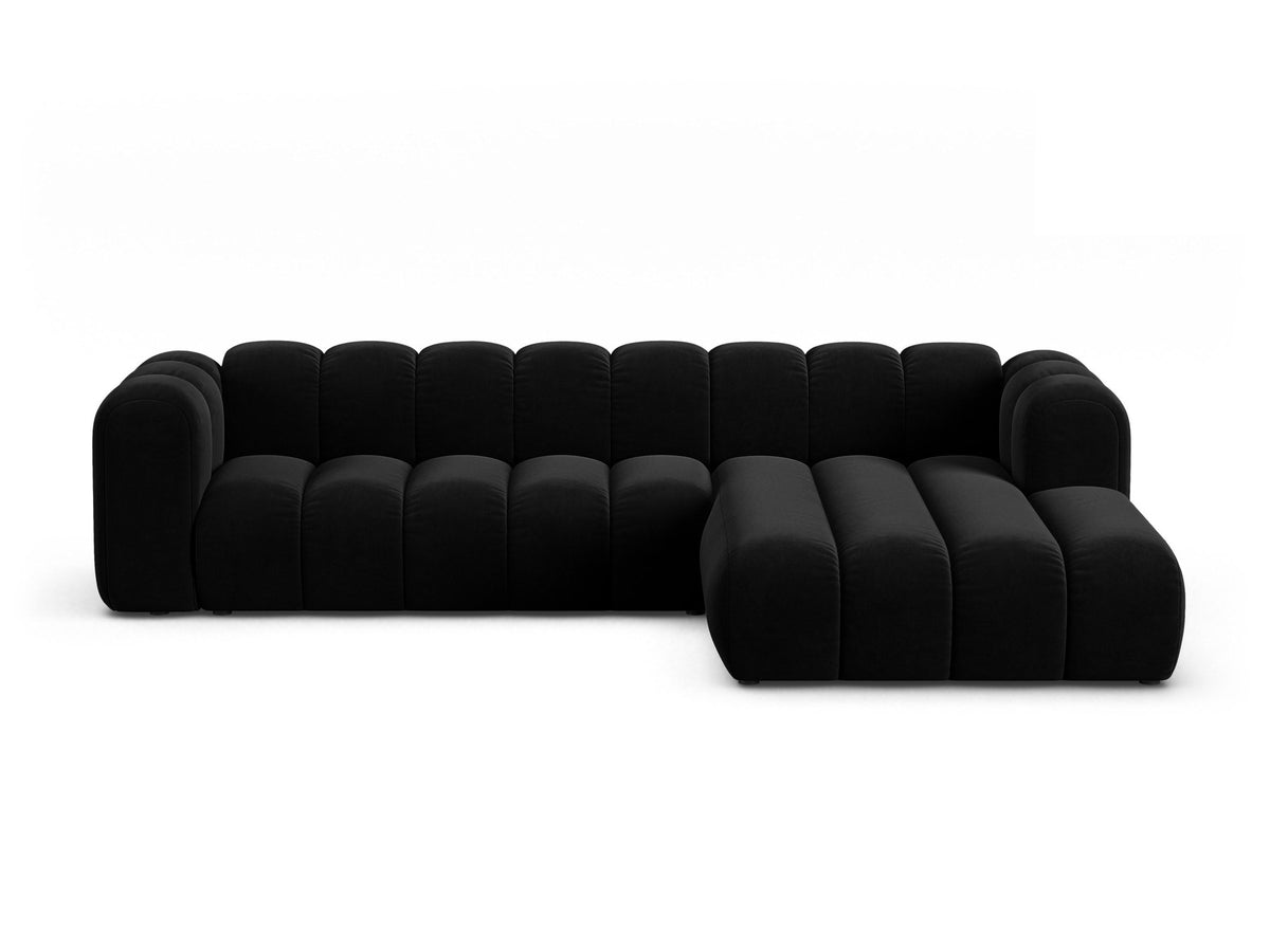 Linksseitig ausgerichtetes Ecksofa Lupine mit Samtbezug in leichtem Beige, schwarzen Kunststoffbeinen und tiefer Sitzfläche, Frontalansicht