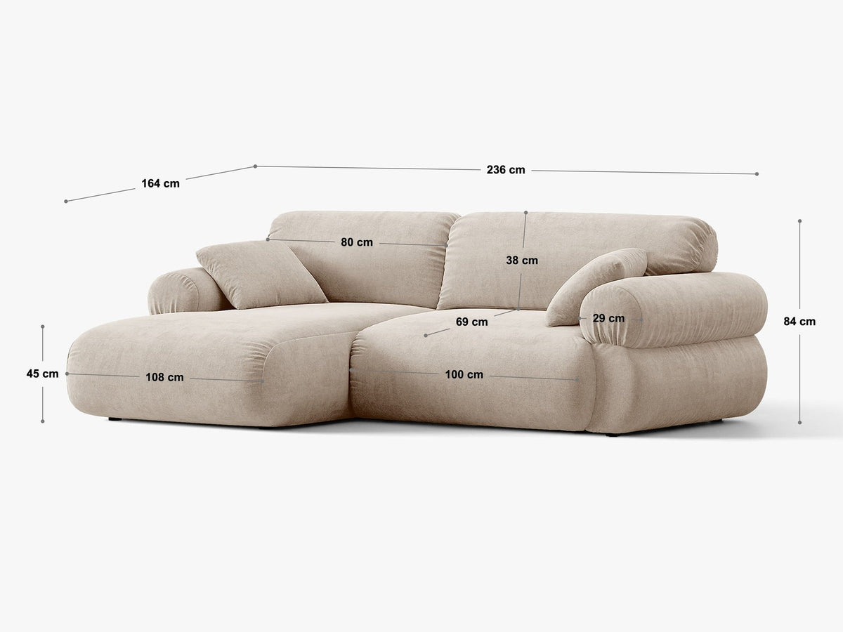 Beiges L-Ecksofa Ophelia von Micadoni mit Stoffbezug Liberty, schwarzen Kunststoffbeinen und niedriger, abgerundeter Sitzform.
