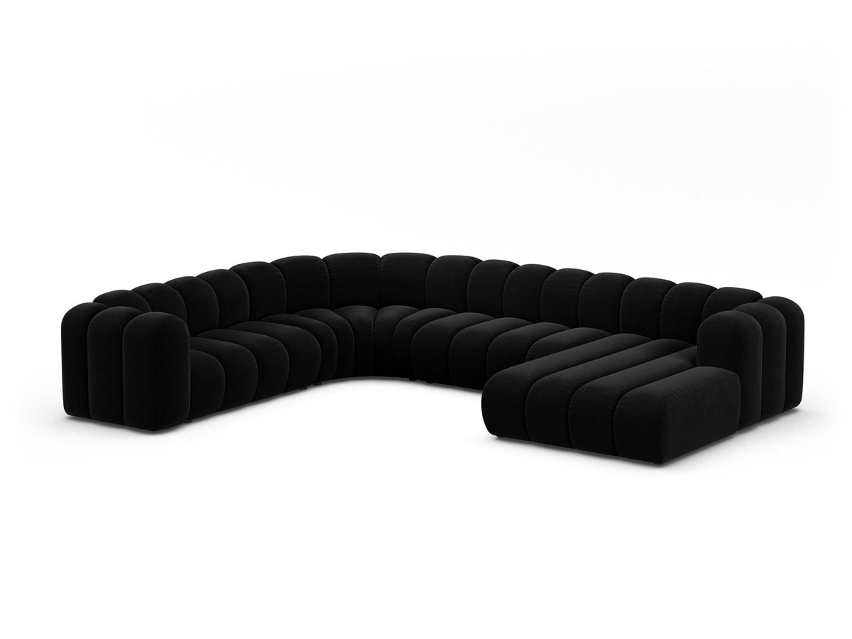 Foto eines modularen Ecksofas links in leichtem Beige aus Samtstoff Venus, mit schwarzen Kunststoffbeinen und breiter Sitzfläche.