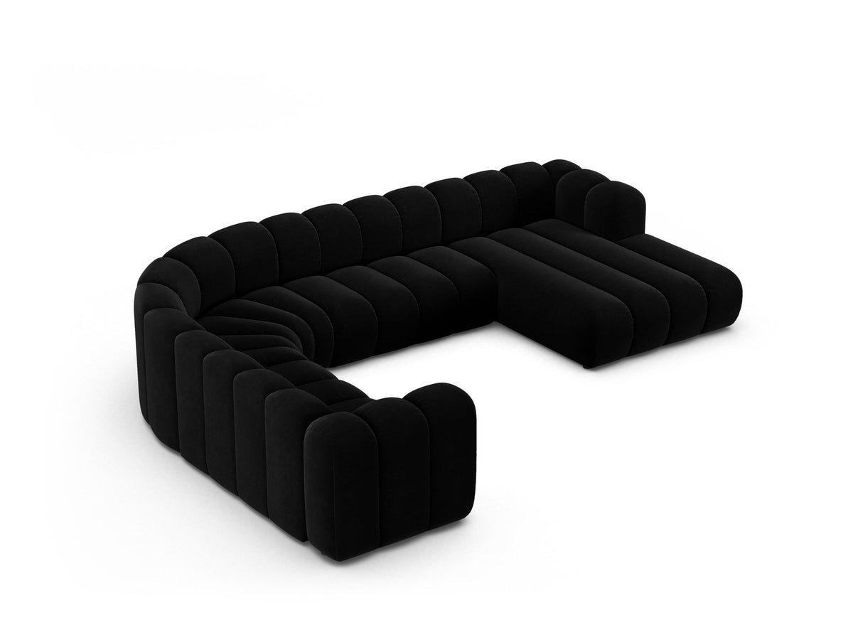 Foto eines modularen Ecksofas links in leichtem Beige aus Samtstoff Venus, mit schwarzen Kunststoffbeinen und breiter Sitzfläche.