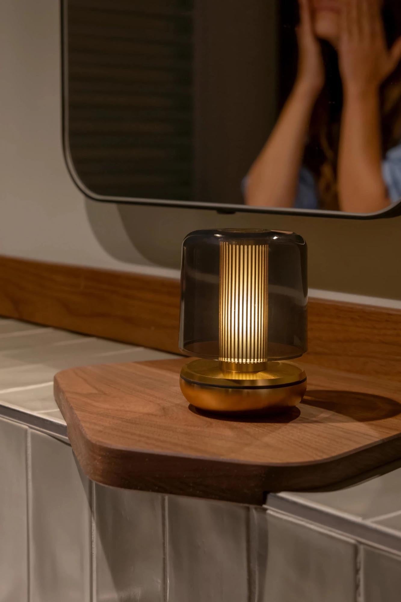 Die Firefly Tischlampe von Humble Light besticht durch smoked Glas und goldene Details, 11.8x8.6cm, perfekt für elegantes Ambiente.