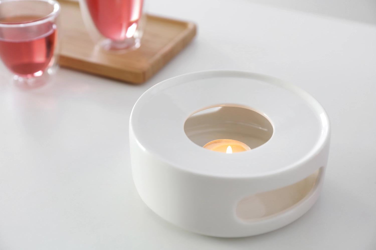 Elegantes Teestövchen aus weissem Porzellan, 14 cm breit, 5,6 cm hoch, minimalistisches Design, ideal für entspannte Teestunden.