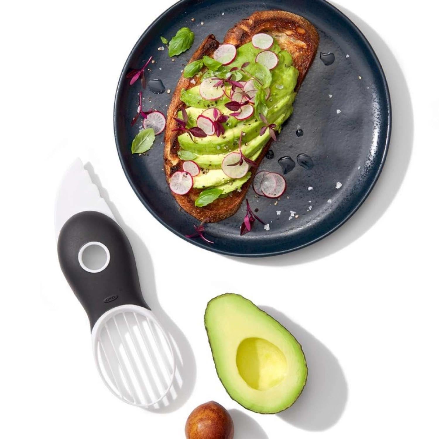 Der weiße OXO 3-in-1 Avocadoschneider: Praktisches Küchenwerkzeug zum Schneiden, Entkernen und Portionieren von Avocados.