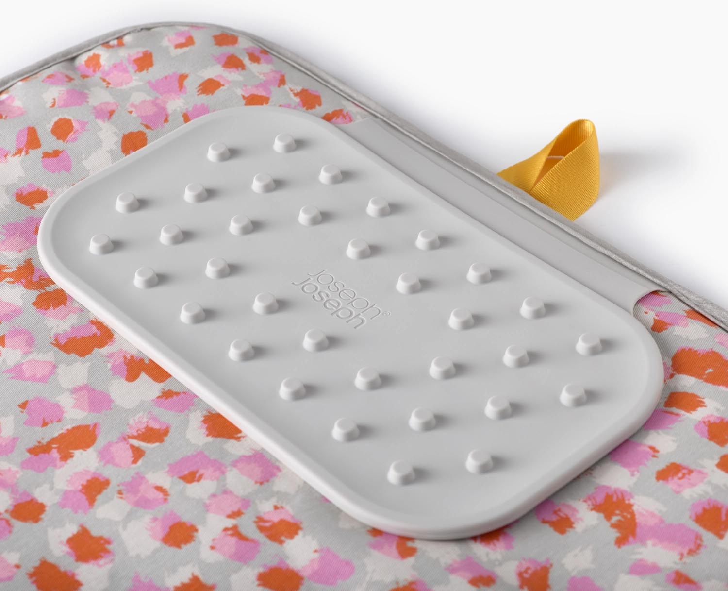 Entdecken Sie die faltbare Swift Bügelmatte von Joseph Joseph in Peach Blossom – ideal für platzsparendes, komfortables Bügeln mit innovativer DripLock™-Technologie.