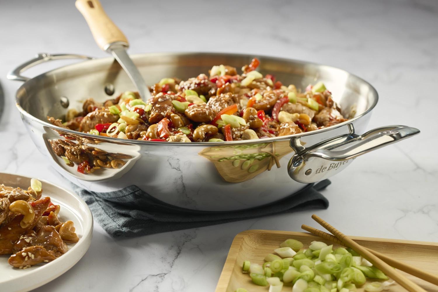 Eleganter Edelstahl-Wok von de Buyer, 32 cm, mit zwei Griffen, perfekt für gleichmässiges Garen und vielseitige Kochmöglichkeiten.