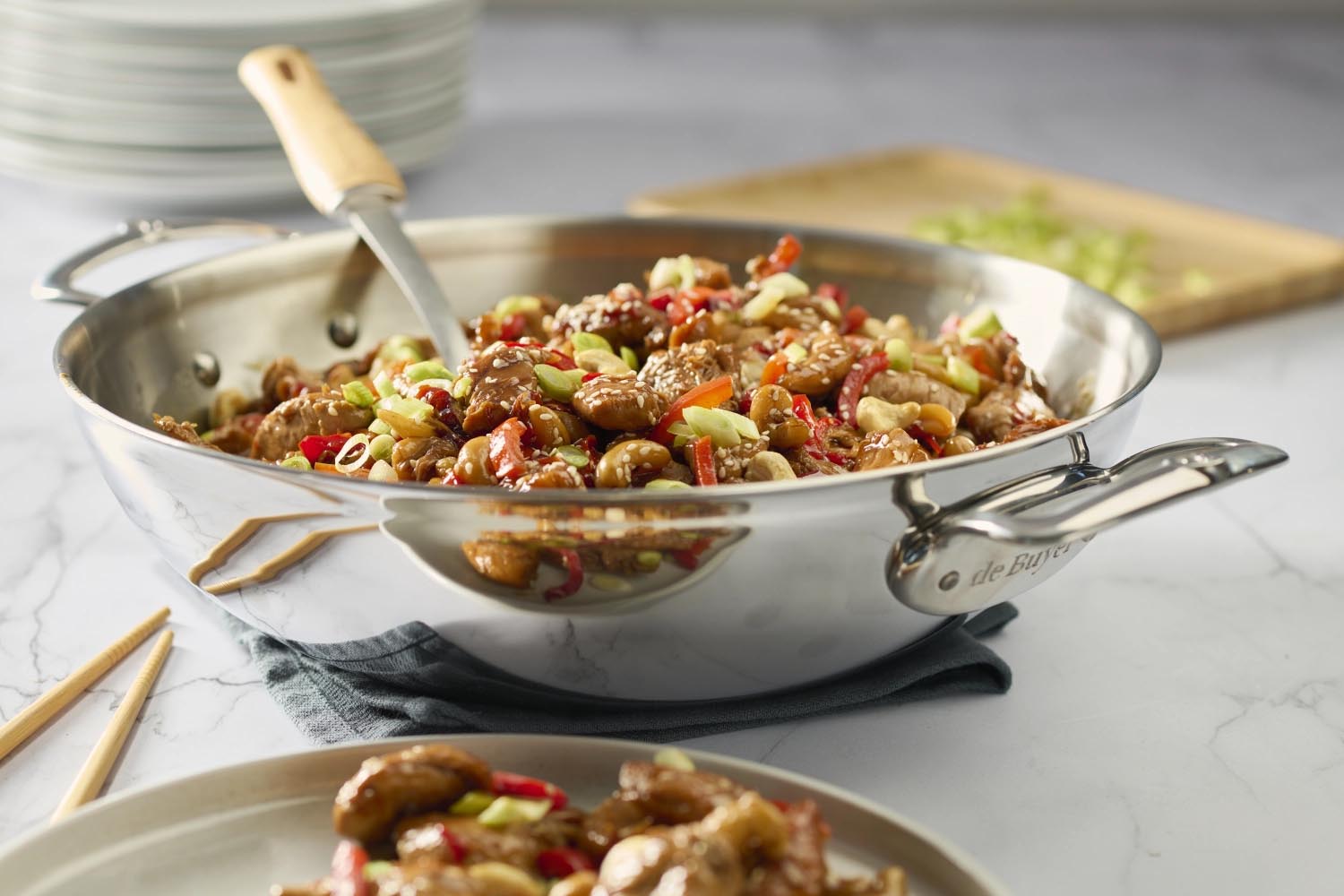 Hochwertiger Edelstahl-Wok von de Buyer, 32 cm, mit zwei Griffen, ideal für gleichmässiges Kochen und vielseitige Gerichte.