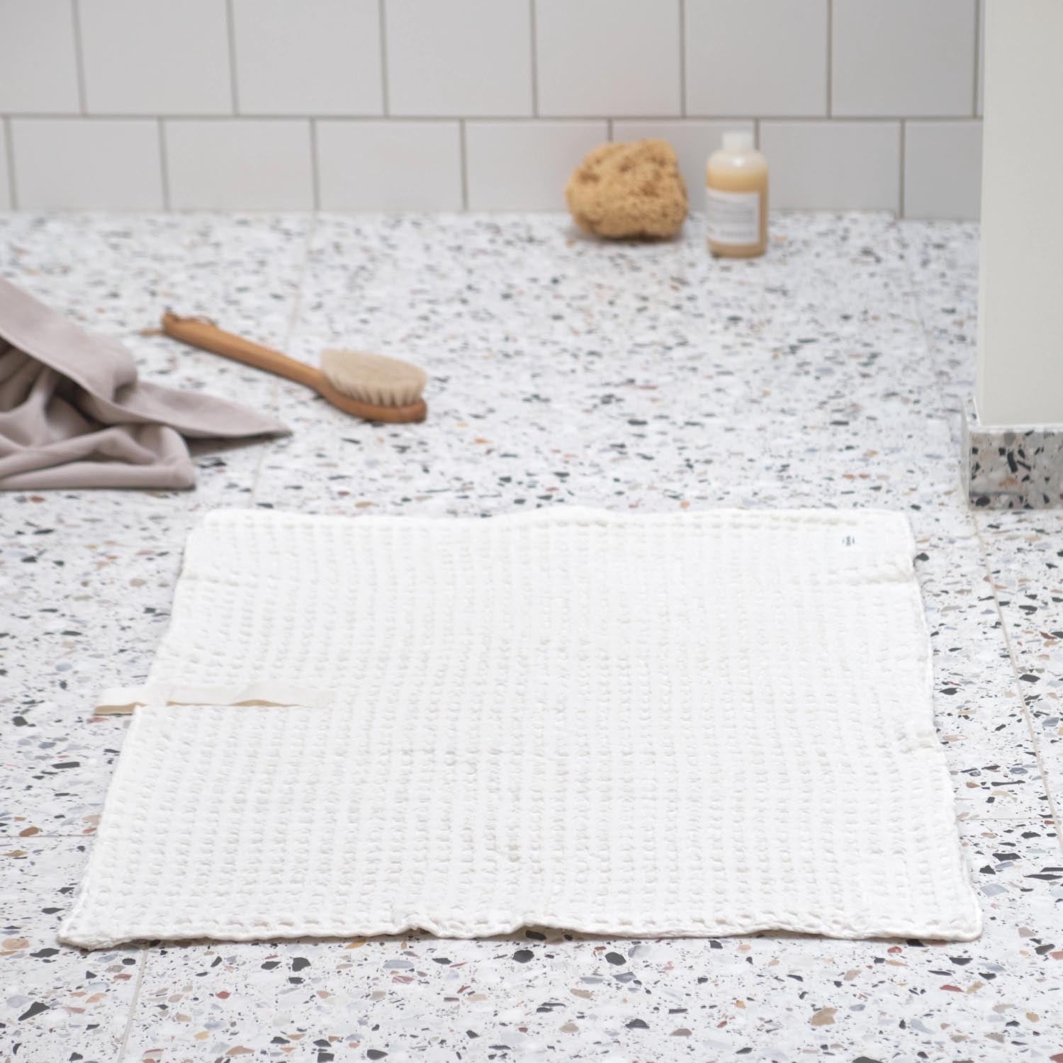 Luxuriöse Badematte aus Bio-Baumwolle, 80x55cm, in natürlichem Weiss. Weiche Waffelstruktur, nachhaltig und stilvoll.