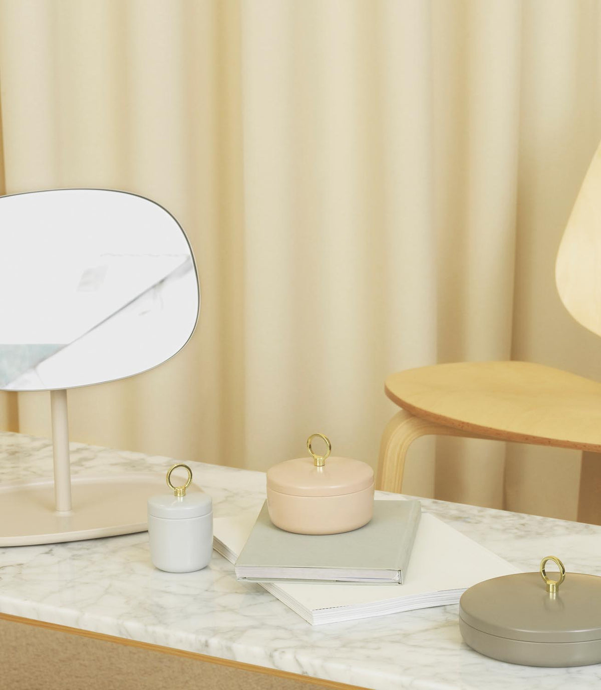 Tischspiegel Flip von Normann Copenhagen mit rundem Glasspiegel und Fuss aus beschichtetem Stahl in organischer Form, Farbe Schwarz.