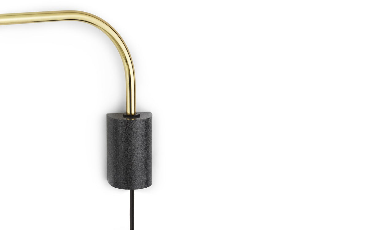 Wandleuchte Grant EU von Normann Copenhagen: Granit-Sockel in Metallic, schlanker Metallarm mit rundem Lampenschirm an Kugelgelenk.