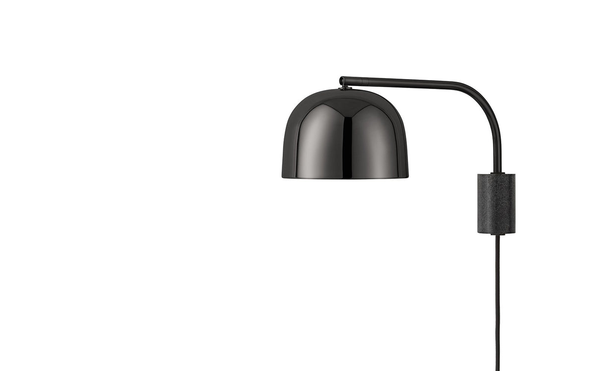 Wandleuchte Grant EU von Normann Copenhagen: Granit-Sockel in Metallic, schlanker Metallarm mit rundem Lampenschirm an Kugelgelenk.