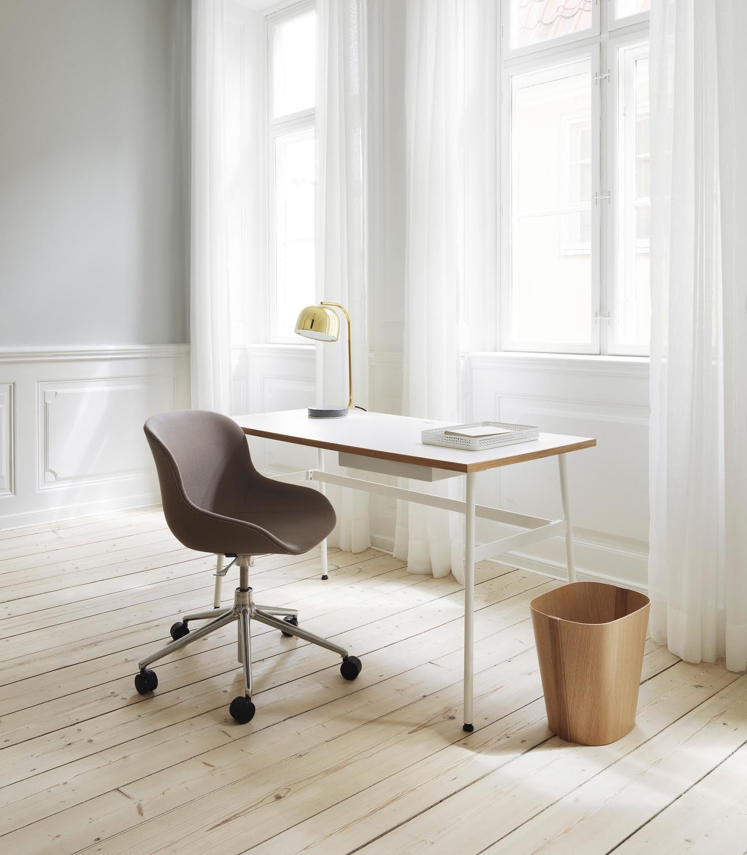 Der Hyg Drehsessel von Normann Copenhagen vereint Hygge, Komfort und Stil mit sanften Linien und Rollen für flexible Gemütlichkeit.
