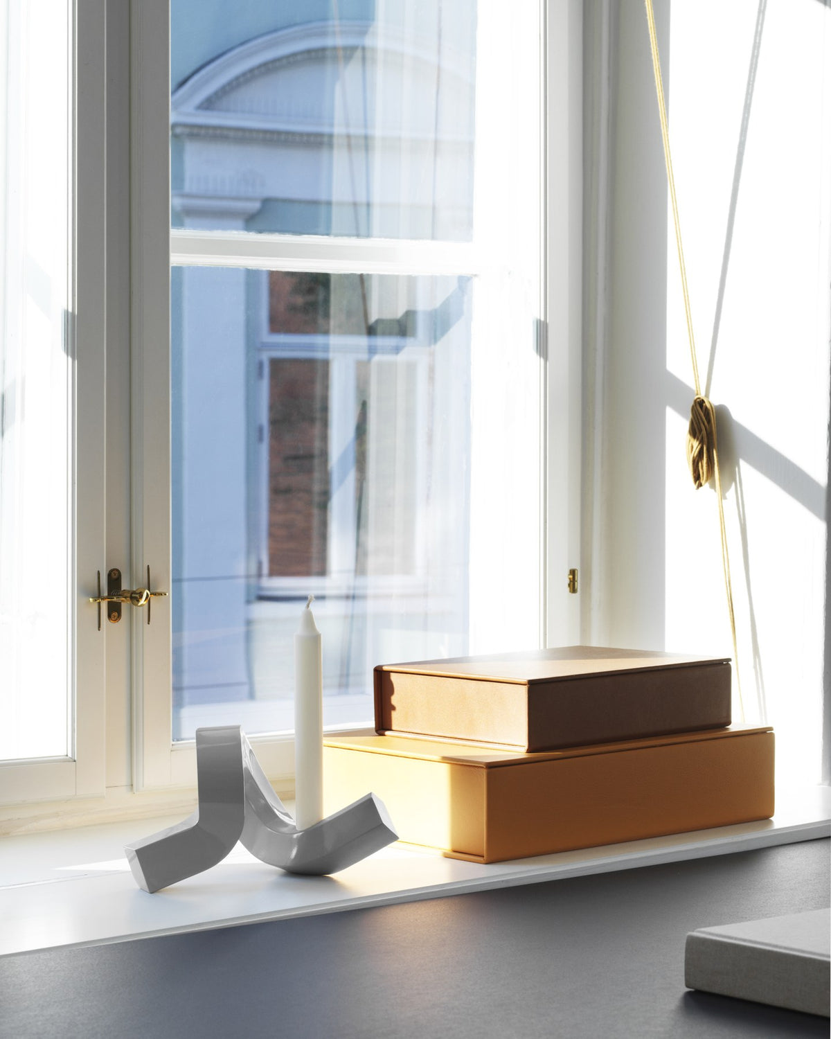 Kerzenhalter Crooked von Normann Copenhagen aus lackiertem Aluminium in Warmes Grau mit geschwungener, skulpturaler Form.
