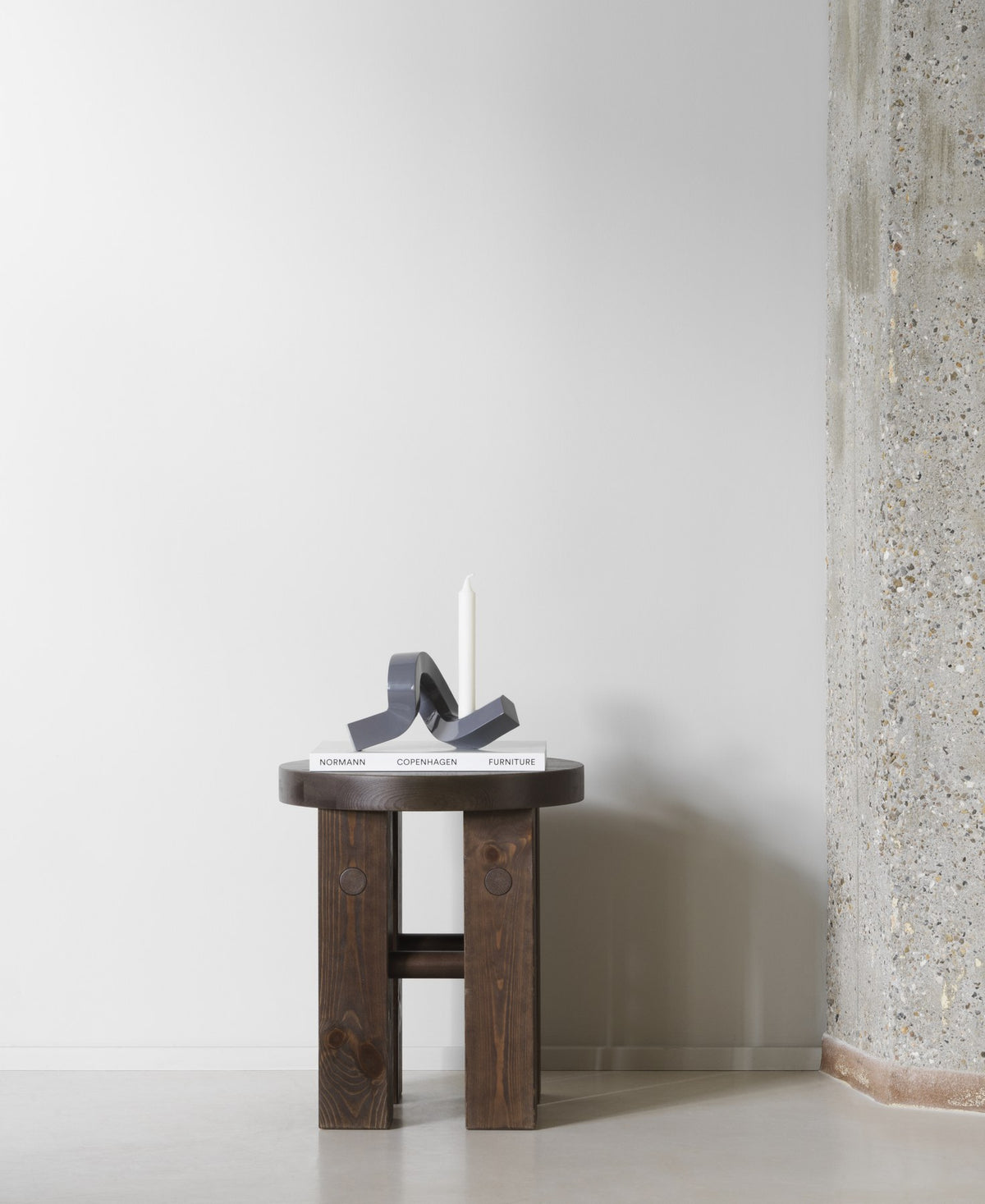 Kerzenhalter Crooked von Normann Copenhagen aus lackiertem Aluminium in Warmes Grau mit geschwungener, skulpturaler Form.